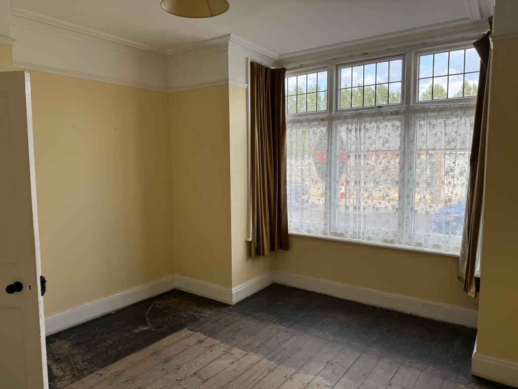 Lot: 38 - THREE-BEDROOM HOUSE IN NEED OF IMPROVEMENT - Living room with painted walls and bare flooring